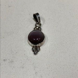 .925 stamped silver pendant with purple stone.